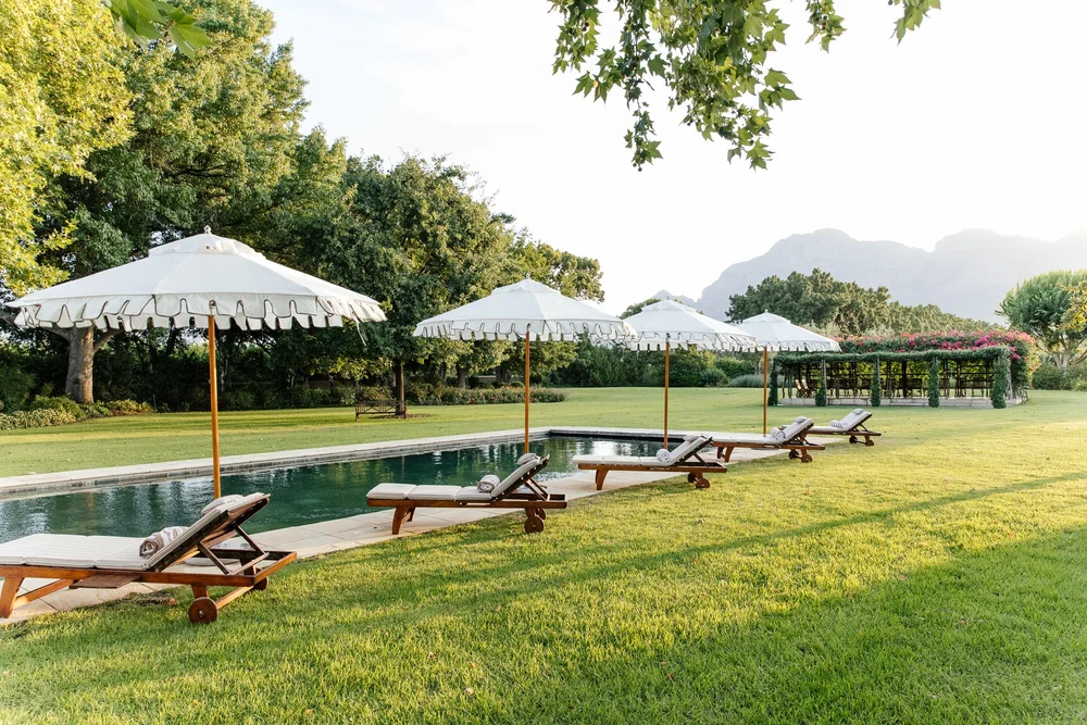 The pool lawn and umbrellas with mountains beyond at Nieuwe Sion