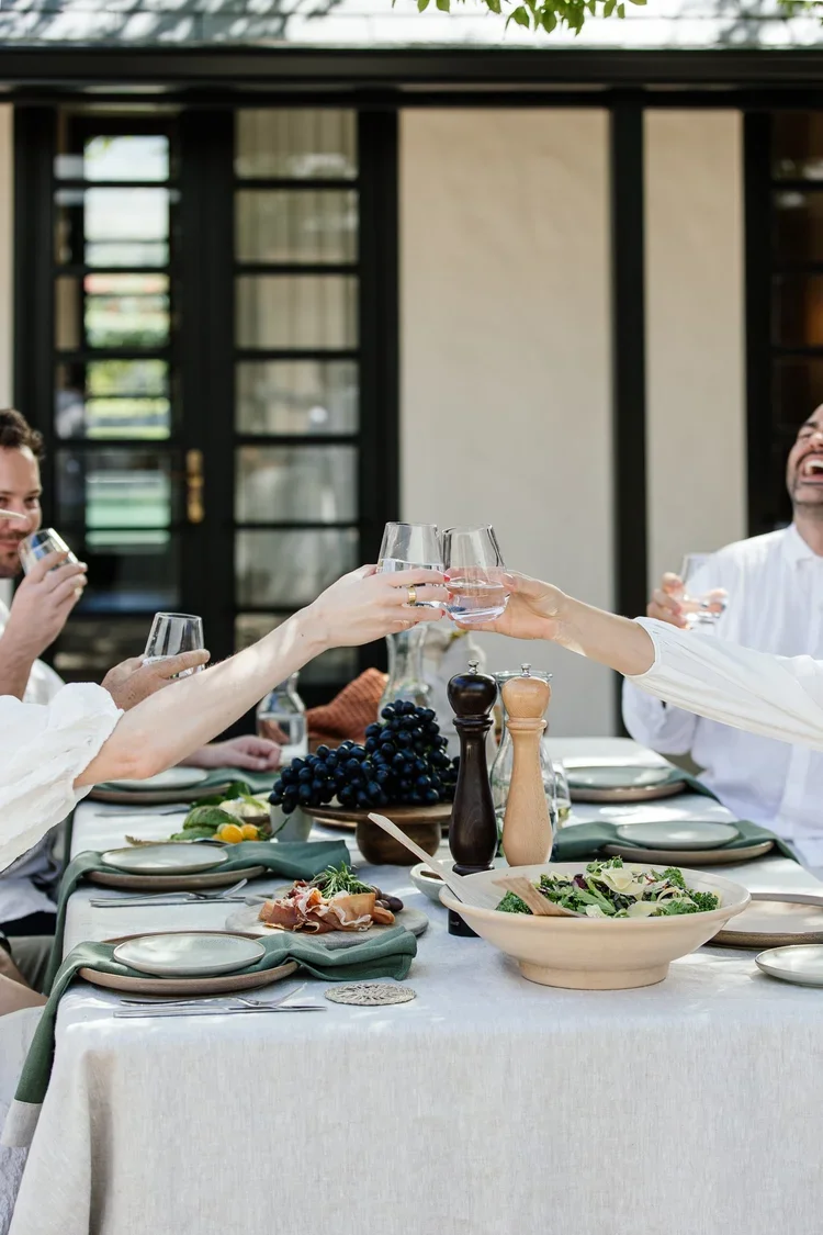 Guests dining together around a harvest table at Nieuwe Sion